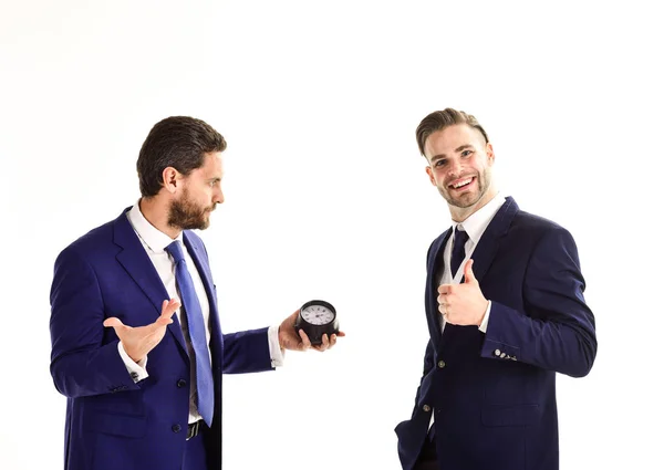 Businessman holds clock with thoughtful face and his partner — Stock Photo, Image