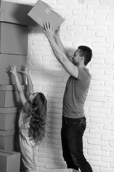 Daughter puts hands up and father puts boxes in pile