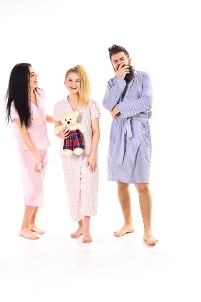 Mannen med skägg och mustasch, Söt blond och brunett flickor med leksak Björn bara vakna upp. Flickor med skäggiga macho i pyjamas och morgonrock i morgon, isolerade vit bakgrund. Sömnig morgonen koncept — Stockfoto