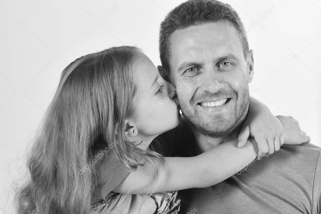 Girl and man with happy smiling face isolated on white background. Daughter and father hug each other. Schoolgirl kisses her dad