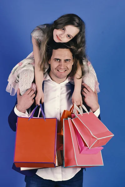 Shopping, presents and family concept. Girl and man with happy faces hold shopping bags — Stock Photo, Image
