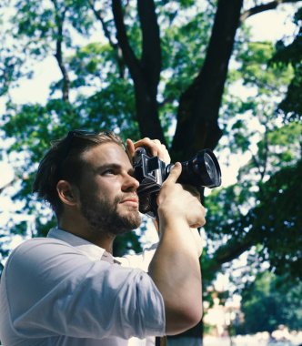 Fotoğrafçı büyük mercekli retro kamera tutuyor.