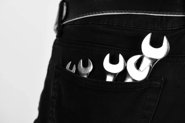 Wrench tools in jeans pocket on white background. — Stock Photo, Image