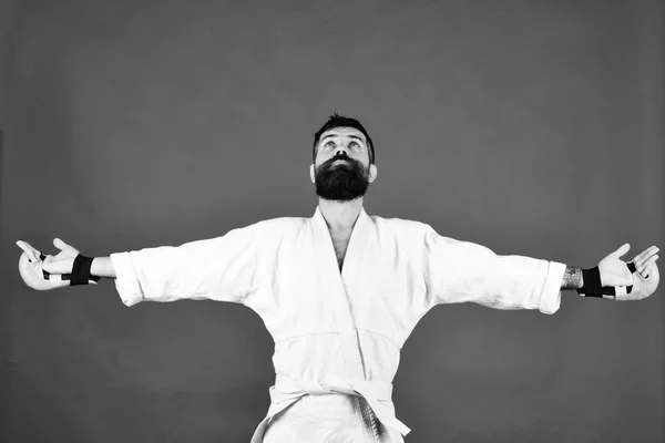 Karate man with blessed face in uniform and boxing gloves.