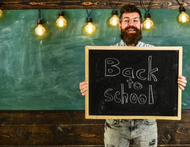 Lise kavramı. Gözlük öğretmen okul için başlıklı yazı tahtası tutar. Sakal ve bıyık neşeli gülümseyen yüz memnuniyetle öğrencilerin, kara tahta arka plan ile adam