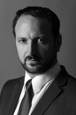 Lider anlaşmazlıkları koyu gri arka plan üzerine siyah ve beyaz yerleşir. Sakallı adam ve ciddi bir yüz yönetir iş.