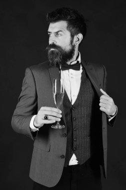 Sakallı adam şampanya bardağı tutuyor..