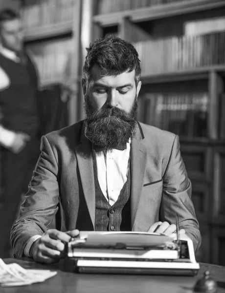 Uomo con la barba e la faccia occupata sedersi in biblioteca — Foto Stock