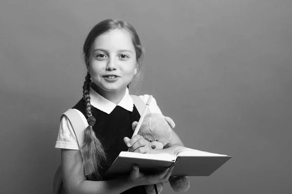 Menina com tranças e rosto feliz. Criança de uniforme escolar — Fotografia de Stock