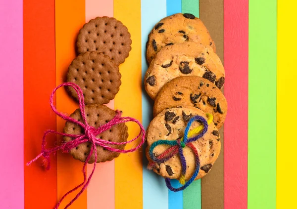 Biscoitos caseiros e de consumo em colorido como fundo do arco-íris. Conceito de biscoitos. Biscoitos comprados ou assados em casa. Comparação de cookies fabricados e caseiros, vista superior — Fotografia de Stock