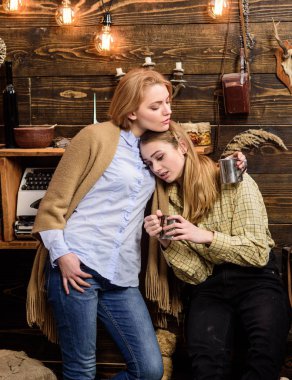 Arkadaşlar hoş akşam, iç arka plan geçirmek. Destek ve sempati kavramı. Arkadaşlar hugs süre var içten konuşma. Kızlar rahat yüzleri metalik kupalar tutun, coziness içecekler ile keyfini çıkarın