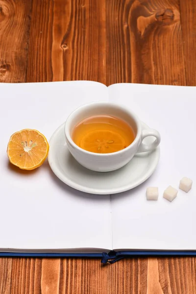 Bebida quente com cubos de açúcar colocados em livro aberto — Fotografia de Stock