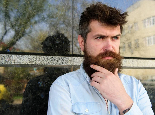 Erkeklik kavramı. Tousled saçlı hippi sakal mesafe içine bakarken dokunur. Adam şüpheli görünüyor. Sakal ve bıyık düşünceli, dalgın yüzünde siyah mermer zemin üzerine olan adam