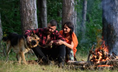 Alman çoban köpeği olan çift şenlik ateşinin yanında.,