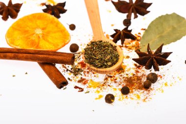 Sıcak içecekler baharat seti. Baharat seti hazırlamak için mulled şarap ya da sıcak içecek, yakın çekim. Baharatlar, kurutulmuş portakal, tarçın, kakule ve beyaz zemin üzerine Hindistan cevizi kaşıkla. Baharat Seti kavramı