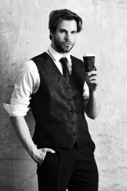 Takım elbiseli bir iş adamının elinde kahve kağıdı.