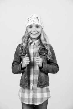 Mutlu çocukluk kavramı. Uzun sarı saçlı çocuk gülümseme. Moda, stil trend. Güzellik, göz saç modeli. Kız kot takım elbise, şapka, turuncu zemin üzerine ekose gömlek.