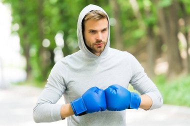 Savaşmaya hazırım. Konsantre yüzlü sporcu, spor eldivenli boks antrenmanı yapan, doğa geçmişi olan. Boksör başlığı dövüşmeye hazır. Boks eldivenli sporcu boksörü eğitimi
