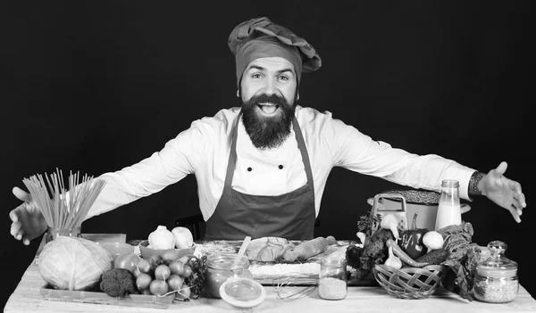 Концепція італійської кухні. Людина з бородою сидить на стільницю на чорному фоні — стокове фото