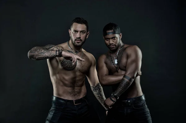 African and hispanic men with sexy bare torso. Men with fit tattooed body. Fashion models with tattoo in jeans. Sportsmen with muscular chest and belly. Sport with fitness and bodycare, vintage filter — Stock Photo, Image