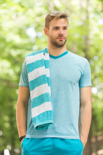 Kısa bir ara veriyoruz. Açık havada koştuktan sonra havlusu olan bir sporcu, doğa geçmişi var. Atletik adam dinleniyor. Havluyla atlet yorucu antrenman sırasında mola verir. Açık havada koşucu egzersizi