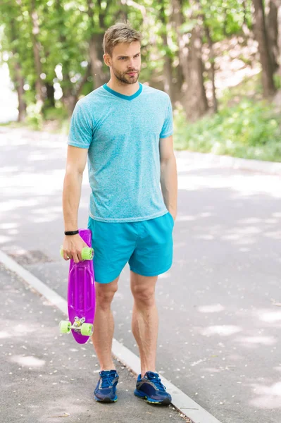 Hala çocukça. Adam penny Yönetim Kurulu, binmeye hazır taşır. Adam sakin yüz kuruş kurulu park doğa arka plan defocused, taşır. Adam kaykay ve sportif yaşam tarzı binmeyi seviyor. Hobi kavramı