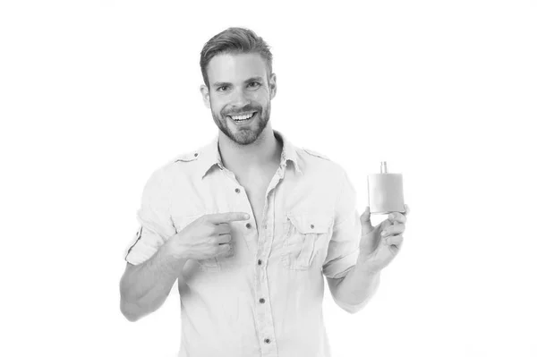 Joyeux macho pointe du doigt à la bouteille de parfum. Homme barbu sourire avec déodorant isolé sur fond blanc. Présentation du concept de produit. Hygiène et santé. Se rafraîchir, noir et blanc — Photo