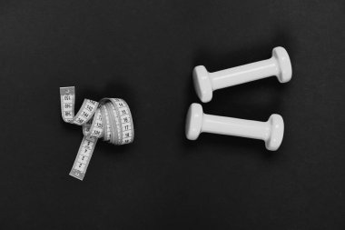 Spor ve sağlıklı yaşam konsepti. Şekillendirme ve fitness ekipmanları. Barbell rulo şerit metre yakınındaki