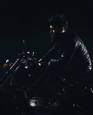 Bisikletçileri eğlence kavramı. Maço, vahşi Motorcu deri ceket sürme motosiklet gece zaman, kopya alanı. Sakallı, motorcu karanlık, siyah arka planda motorlu bisiklet üzerinde oturan deri ceketli adam