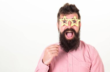Superstar kavramı. Adam parti sahne yıldız şekilli gözlük, beyaz arka plan tutar. Hipster sakal ve bıyık neşeli sürpriz yüzünde yıldız ile poz ile gözlük, kopya alanı şeklinde