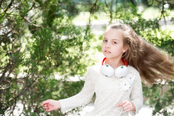 Danse d'enfant à la musique dans le parc d'été. Petite fille profiter de la musique dans les écouteurs en plein air. Danseuse avec de longs cheveux volants. Mélodie sonore et mp3. Plaisir d'été et joie — Photo
