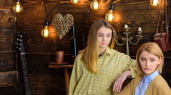 Los amigos pasan la tarde agradable en la casa de guardabosques, el fondo interior. Las chicas en caras tranquilas disfrutan de un ambiente cálido mientras descansan. Dos amigos se reúnen dentro de la cafetería, pasando tiempo y hablando — Foto de Stock