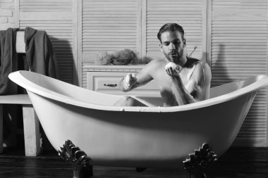 Cinsellik ve gevşeme kavramı. Küvet içinde köpük ile oynarken maço. Adam banyoda