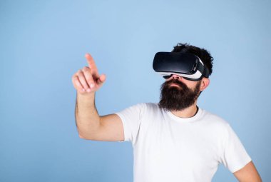 Hipster Vr bardaklarda yeni cihaz, modern teknoloji kavramı denetler. Sakallı adam sanal gerçeklik oyunda emilir. Üzerinde mavi arka plan izole dijital dokunmatik ekran arayüzü kullanarak nerdy sakallı