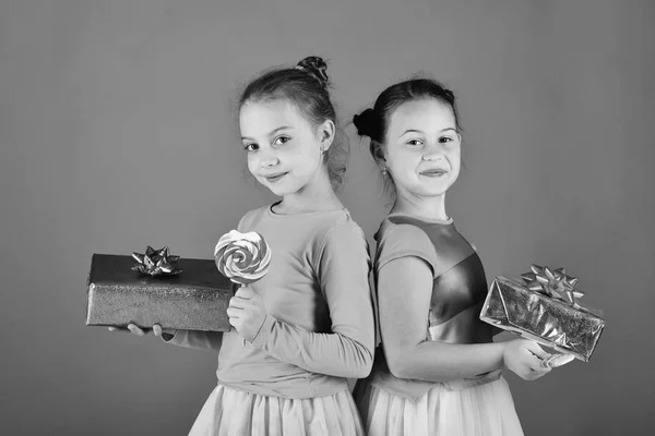 Happy Dessert Konzept. Schwestern mit Lutschern, Schachteln und Tüten. Kinder essen bunte Karamellen — Stockfoto