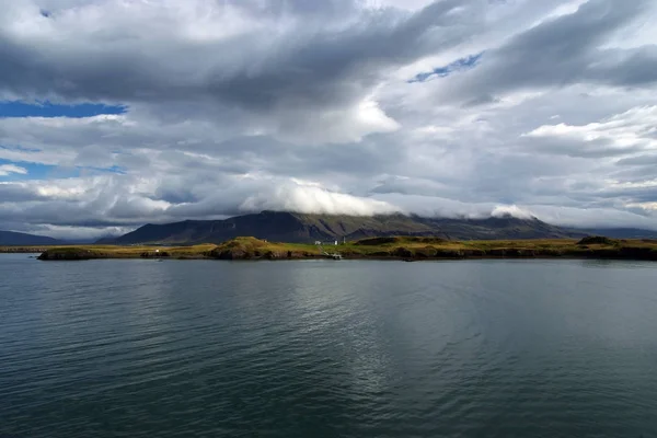 Agua de mar en la costa de montaña bajo el cielo nublado en Rejkjavik, Islandia. Mar en el paisaje de montaña. Belleza de la naturaleza salvaje. Clima y ecología. Wanderlust y vacaciones — Foto de Stock