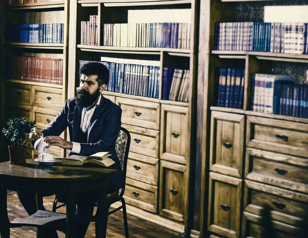 Aristokrat yaşam tarzı kavramı. Klasik takım elbiseli adam vintage iç, Kitaplığı'nda oturur