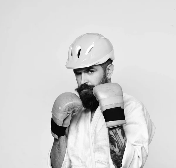 Combat master gets ready to fight. Karate man with serious face in golden boxing gloves — Stock Photo, Image