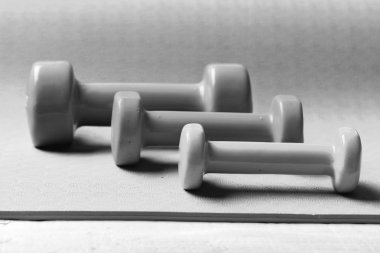 Mor zemin üzerine pembe, yeşil ve mavi plastik dambıl. Barbell farklı renklerde desen, yerleştirilen yakın çekim