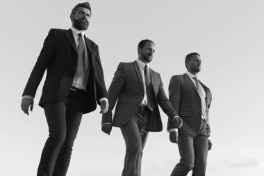 Şirket liderlerinin mavi gökyüzü arka plan başarı için adım olun. İş başarı ve işbirliği kavramı. Emin yüzü olan iş adamları