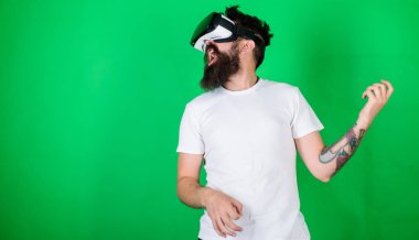 Vr gözlük, yeşil arka planda sakallı adam. Hipster gitarist hevesli yüzündeki modern teknoloji eğlence için kullanın. VR müzisyen kavramı. Vr gözlüklü müzik gitar çalmak öğrenmek