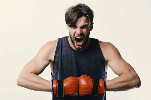 El hombre con cerdas y cara furiosa usa guantes de boxeo. Boxeador hace golpes y golpes como entrenamiento. Deportes y competición —  Fotos de Stock