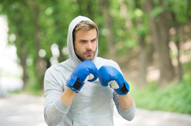Temiz hava boksör egzersiz. Knowckout. Delme adam. Başarı için mücadele. Boks eldivenleri ve doğal peyzaj kaputa adam. Onun boks becerileri eğitim. Mücadele tarihi. Güç ve enerji