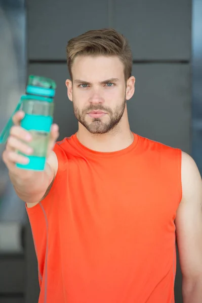 Adam paylaşımı su ile sakallı. Ürün sunmak. Susuzluk ve sağlık. Atlet tutun plastik şişe. Biraz su iç. Eğitimden sonra sulu ve sağlıklı kal. Spor ve fitness — Stok fotoğraf
