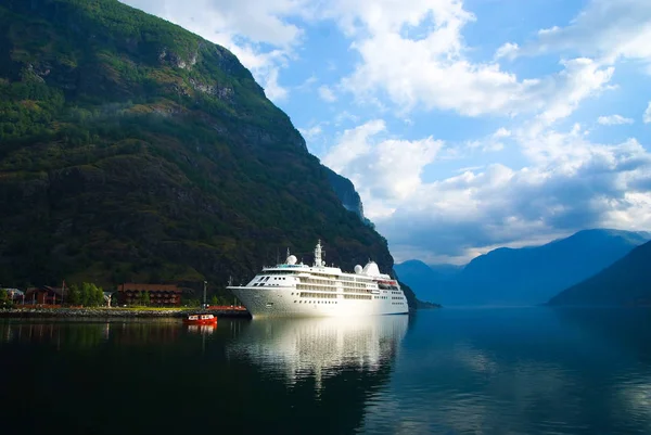 Cruise schip in de zeehaven op berglandschap in Flam, Noorwegen. Oceaanstomer in zee haven met groene bergen. Cruise bestemming en reizen. Zomervakantie en vakantie. Wanderlust en ontdekking — Stockfoto