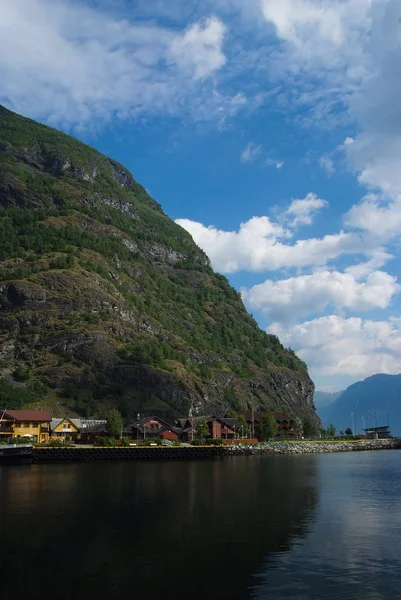 Köy Flam, Norveç'te. Dağ manzarası deniz kıyısında, ülke ev sahipliği yapmaktadır. Fiyort ve bulutlu gökyüzü dağlardaki. Tatil ve yolculuk tutkusu. Seyahat ve keşif — Stok fotoğraf