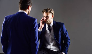 İşadamı ciddi bir yüz ile telefon, kopya alanı tutar.