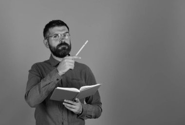 Sakal ve gözlük tutan kitap ve marker ile adam