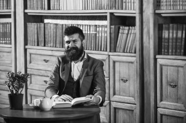 Yüz kitap okuma gülümseyerek tarihinde aristokrat. Oldfashioned adamın yanına Kupası, Çaydanlık. Klasik takım elbiseli adam vintage iç, Kitaplığı'nda oturur,