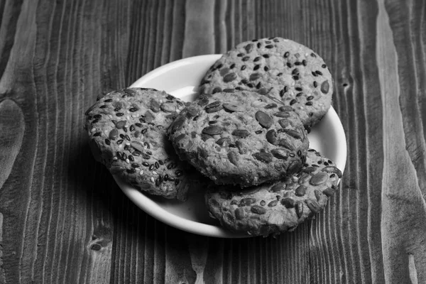 Yulaf ezmesi ahşap arka plan üzerinde yapılmış kurabiye kapatın. Bisküvi tohumları ile plaka üzerine yerleştirilir. Çay için geleneksel snack